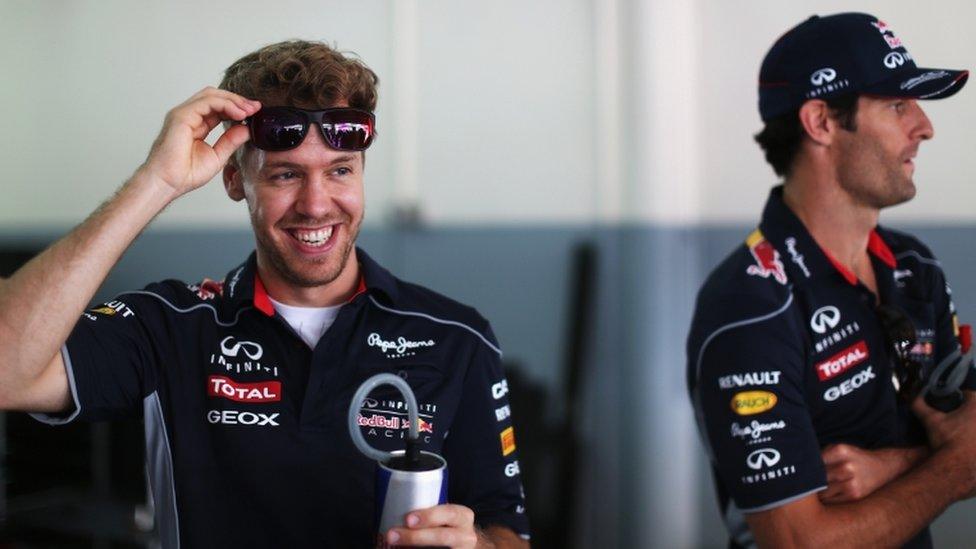 Reigning world champion Sebastian Vettel smiles as team-mate Mark Webber looks on