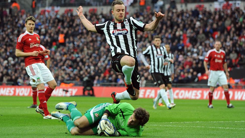 Grimsby Town's Ross Hannah jumps clear of Wrexham goalkeeper Chris Maxwell during the FA Carlsberg Trophy Final at Wembley