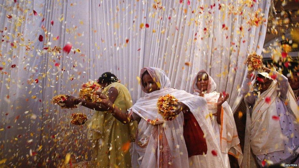 Widows throw flowers into the air during a holi celebration at the Meera Sahavagini ashram in Vrindavan in the northern Indian state of Uttar Pradesh March 24, 2013.