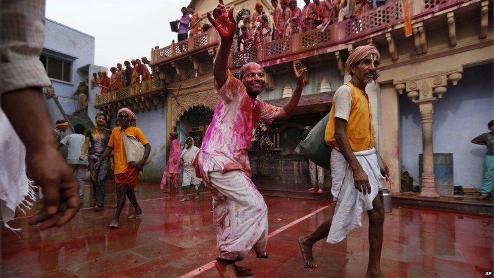 An Indian Hindu devotee covered in colour dances as he arrives at the Nandagram Temple famous for Lord Krishna in Nandgaon 120 kilometres ( 75 miles) from New Delhi, India, Friday, March 22, 2013.