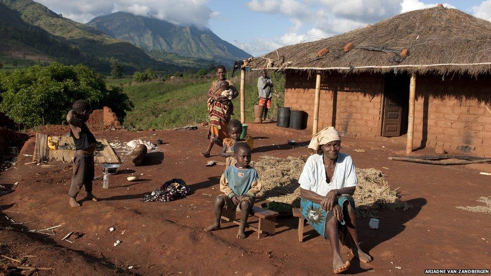 Rural homestead, Gurue, Mozambique showing family outside a simple dwelling.