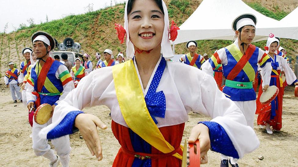 North Korean dancers perform to celebrate a South and North Korea joint ground- breaking ceremony to build an industrial park at Kaesong, 30 June 2003