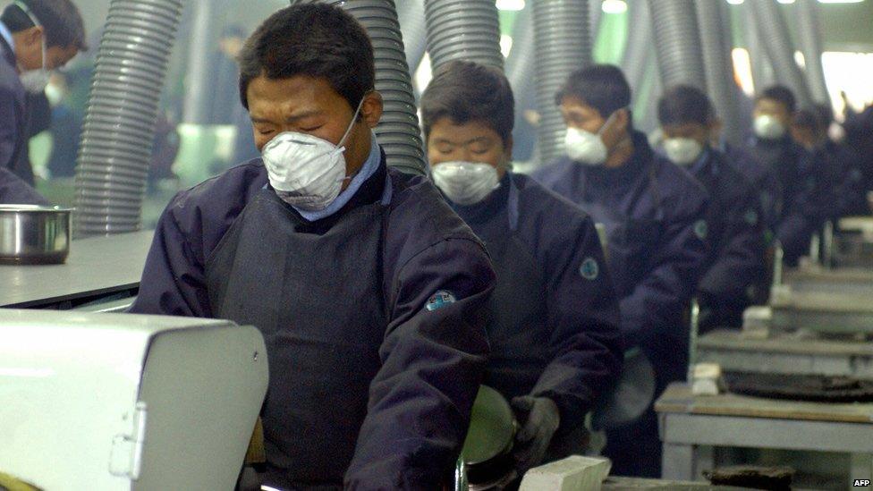 North Koreans work at the factory of Living Art, a kitchenware maker, which became the first South Korean firm to start production in a joint industrial park in the North Korean border city of Kaesong, 15 December 004.