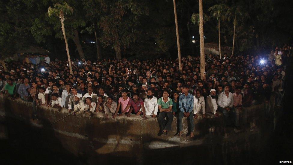 People watch the rescue effort in Thane, Mumbai, on 4 April 2013