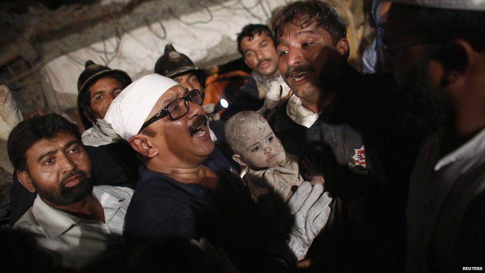 Rescuers carry a child from the rubble in Thane, Mumbai, on 4 April 2013