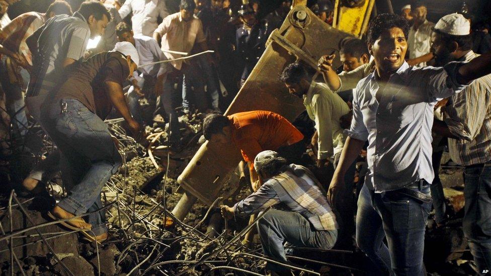 Rescue workers search the rubble at the scene of the collapsed building in Thane, Mumbai, on 4 April 2013