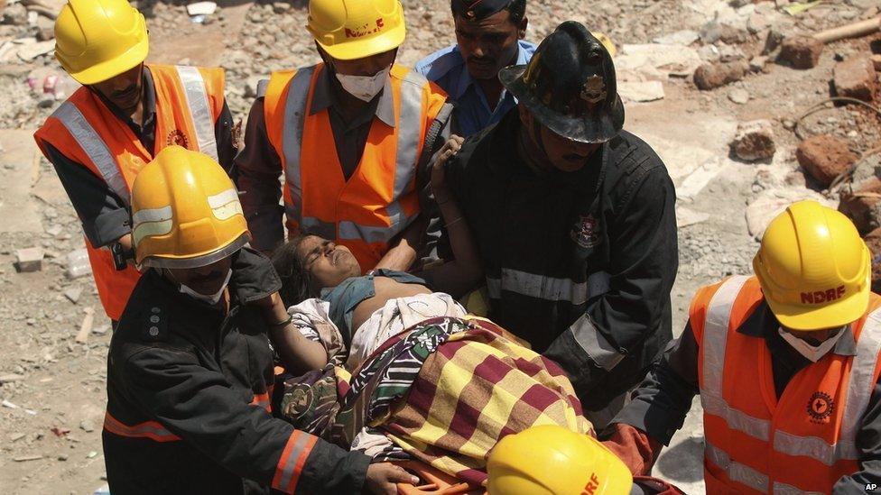 Rescue workers carry an injured woman in Thane, Mumbai, on 5 April 2013