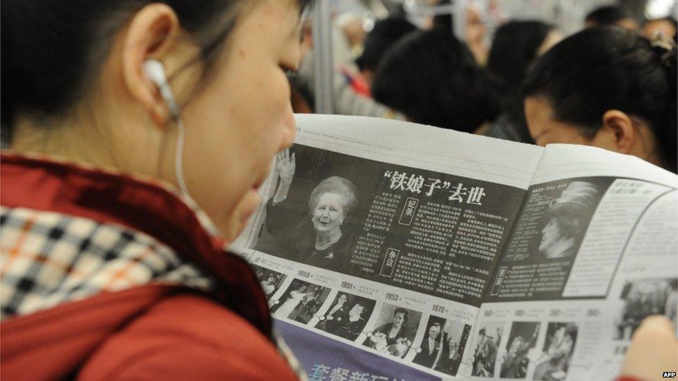 A woman reads about the news of former British prime minister Margaret Thatcher's death in a Chinese newspaper in Shanghai on 9 April 2013.