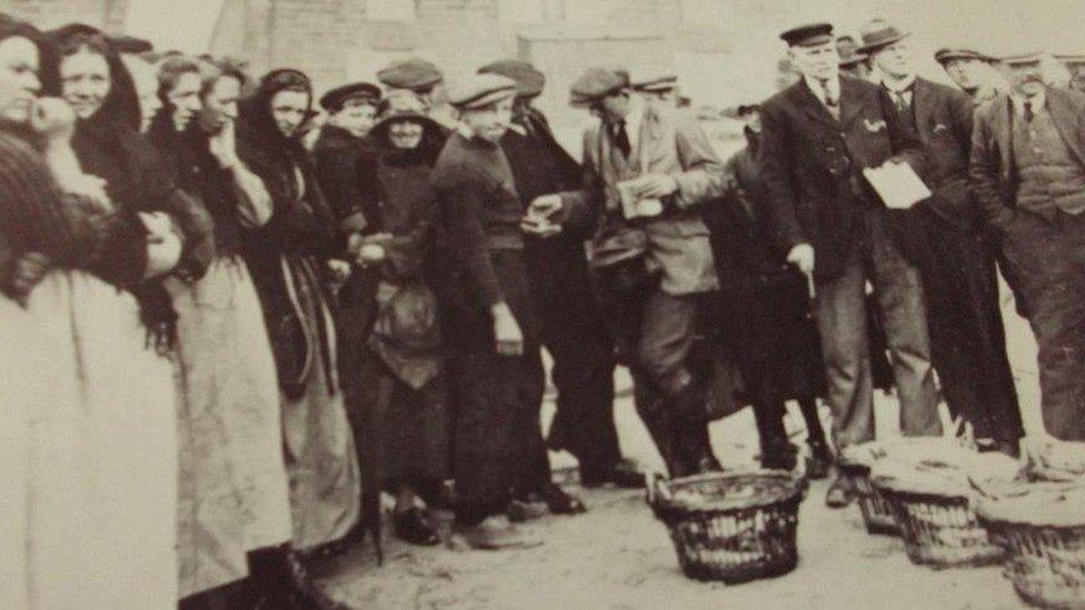 People standing round baskets