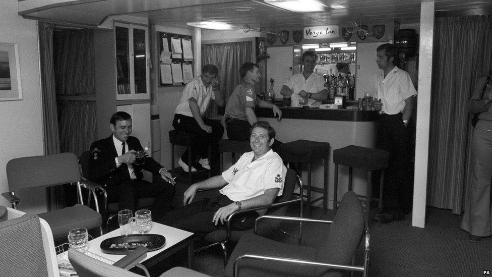 A view of the petty officers' mess in Britannia, with members relaxing over a drink, shows the modern furnishings after the vessel's major refit