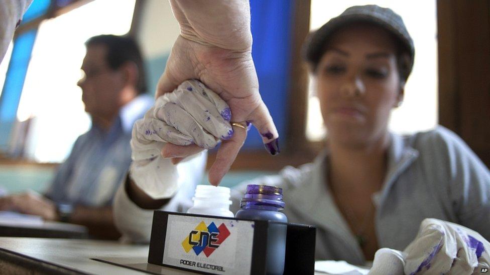 A voter has her finger marked with ink after casting her ballot in the presidential election in Caracas, Venezuela