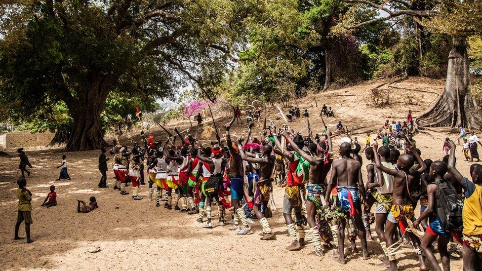 Wrestlers clad in traditional garment line up for a dance