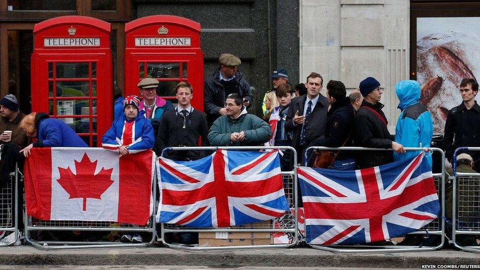 Spectators gather on the route to watch the funeral procession of former British prime minister Margaret Thatcher