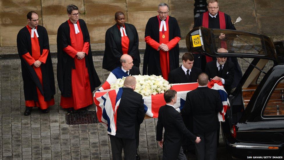 The coffin is transferred to the hearse