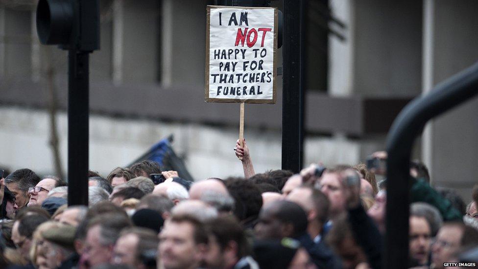 A member of the crowd holds up a sign