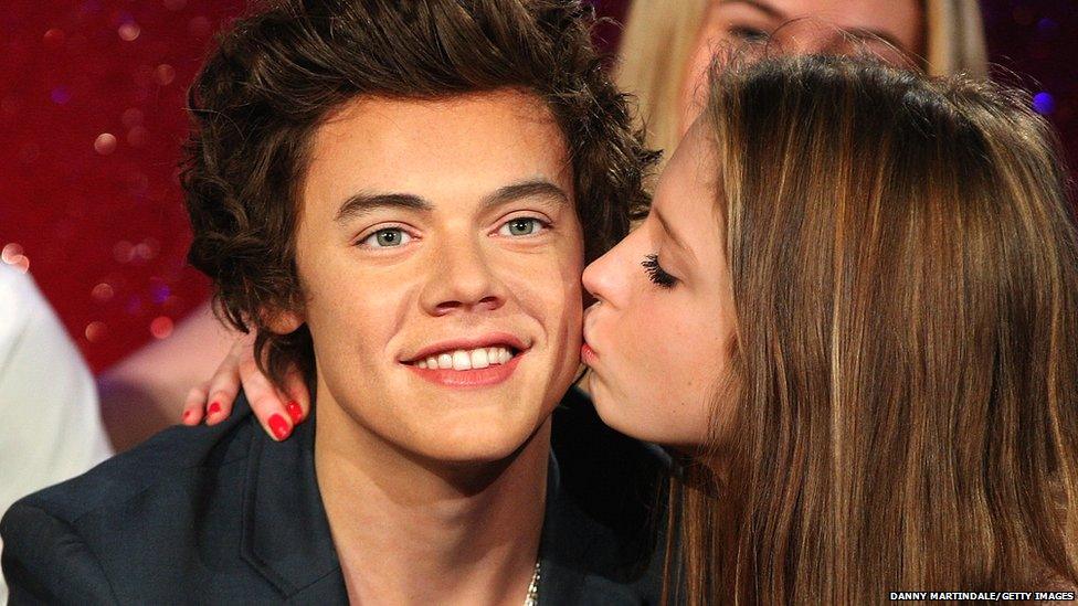 A confused fan kisses the Harry waxwork.