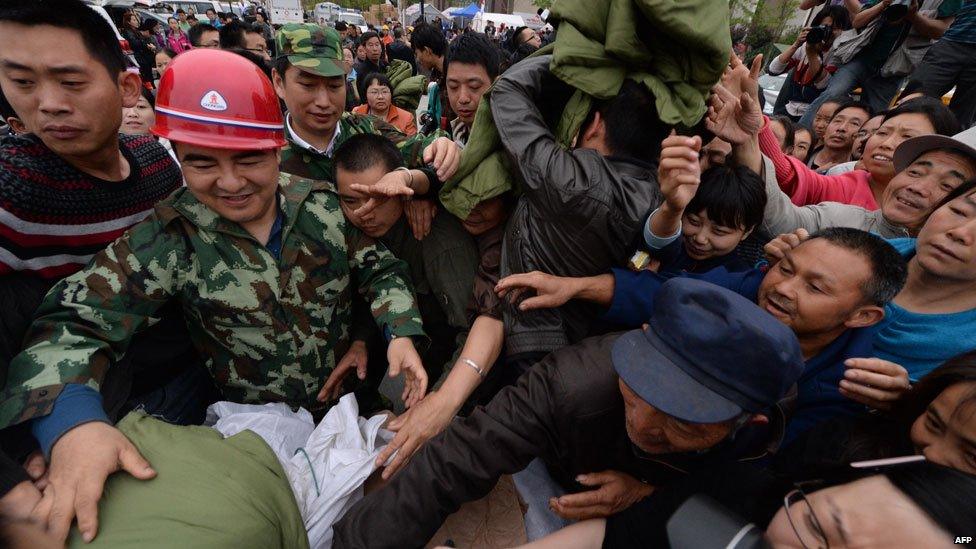 Residents fight over blankets after a magnitude 6.6 earthquake hit Lushan, Sichuan Province on April 21