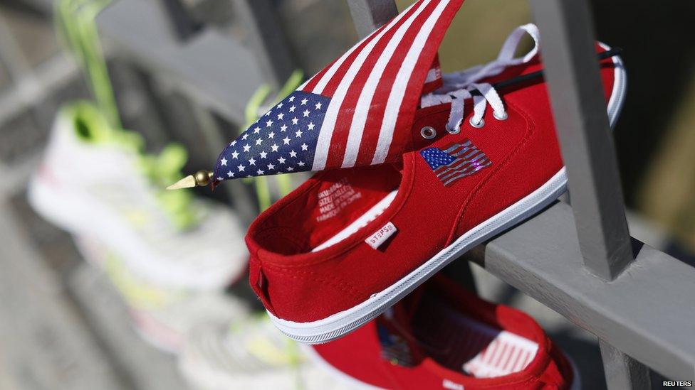 A pair of sports shoes and a US flag hang from the gate of the US embassy in Ottawa, Canada, 22 April