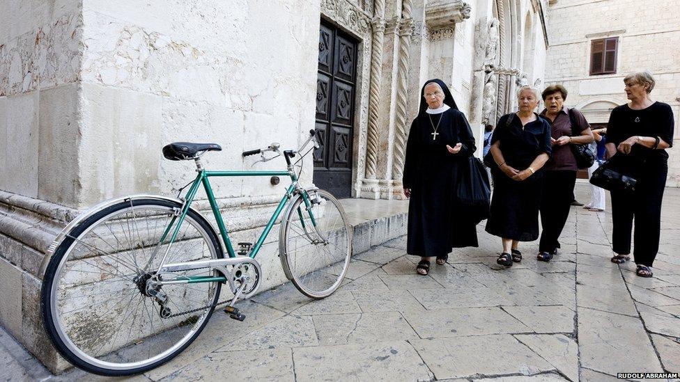 Women and bicycle outside the Cathedral of St Anastasia, Zadar, a picturesque city on Croatia's Adriatic coast.