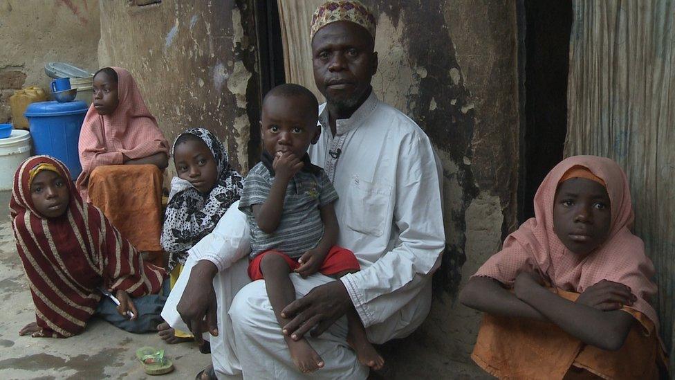 Usman Al Hassan and his children, including on his lap Abubarkar who contracted polio in 2013, on their home in the outskirts of Nigeria's capital, Abuja