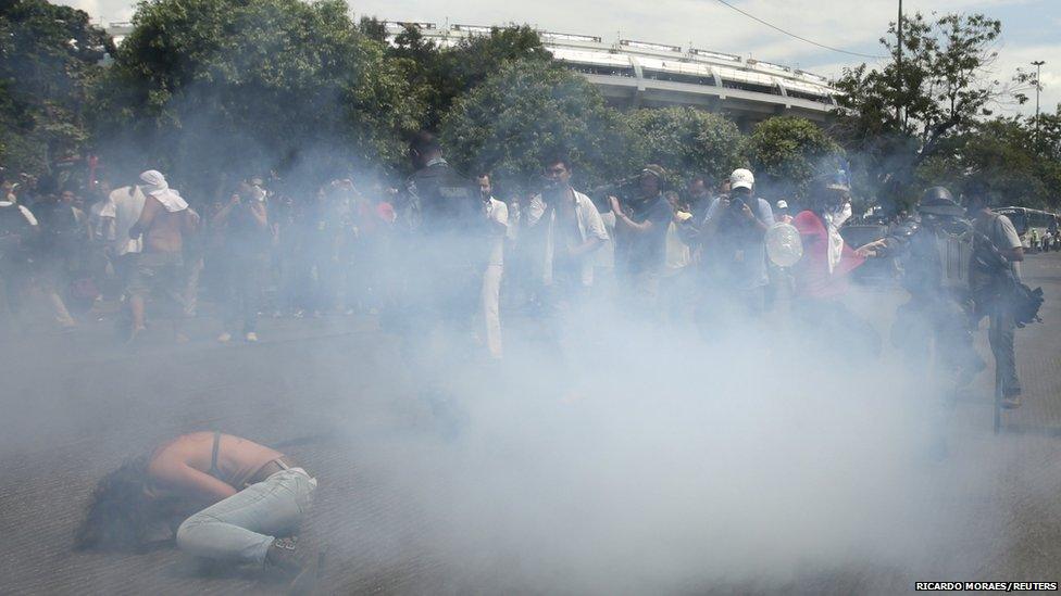 Supporters of a native Indian community living at the Brazilian Indian Museum stand amid tear gas during clashes with military police officers as they protest against the community's eviction in Rio de Janeiro March 22, 2013.