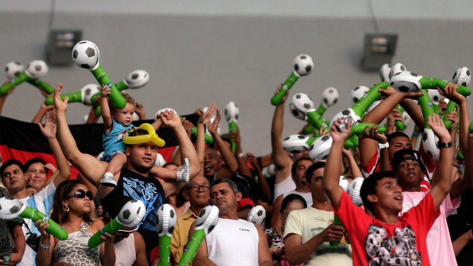 Soccer fans cheer during the re-opening of the newly renovated Maracana Stadium in Rio de Janeiro on Saturday 27 April