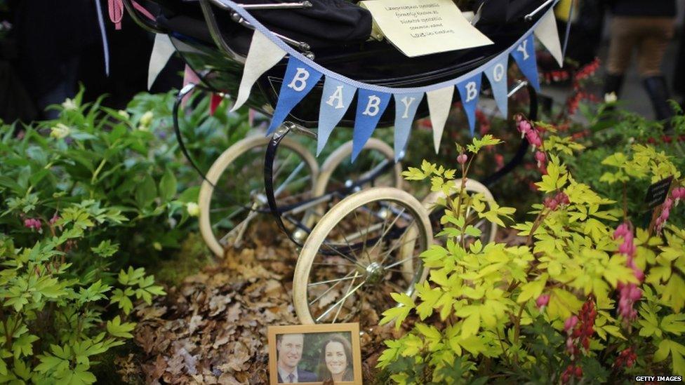 A floral display based around a baby's pram and a photograph of parents to be Catherine, Duchess of Cambridge, and Prince William, Duke of Cambridge