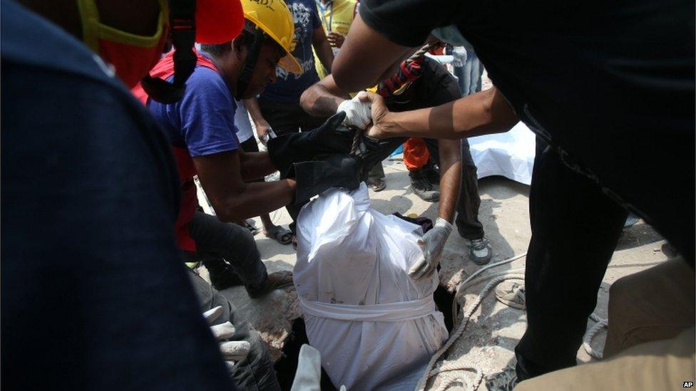 Rescue workers remove a body from the rubble in Savar, Dhaka, Bangladesh (28 April 2013)