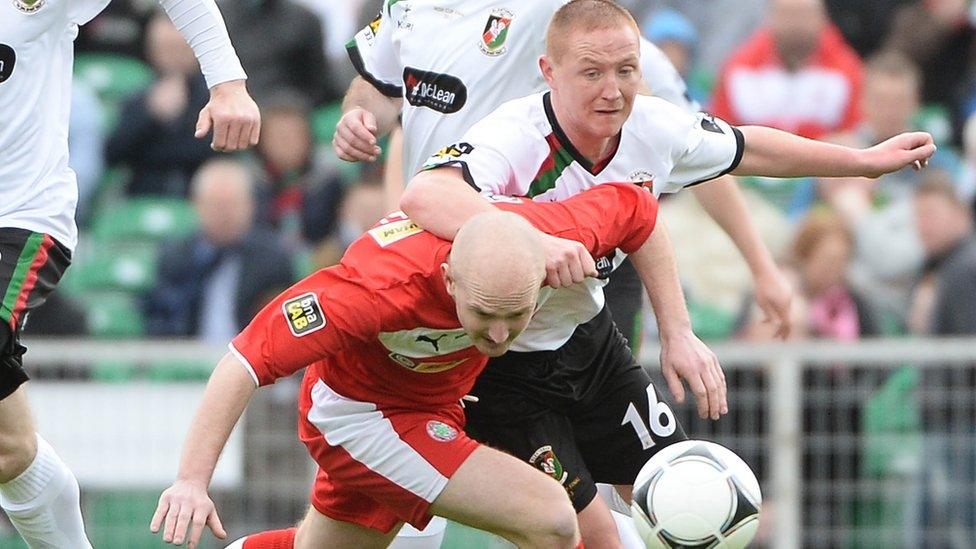 Cliftonville's Ryan Catney holds off Stephen McAlorum in a midfield tussle