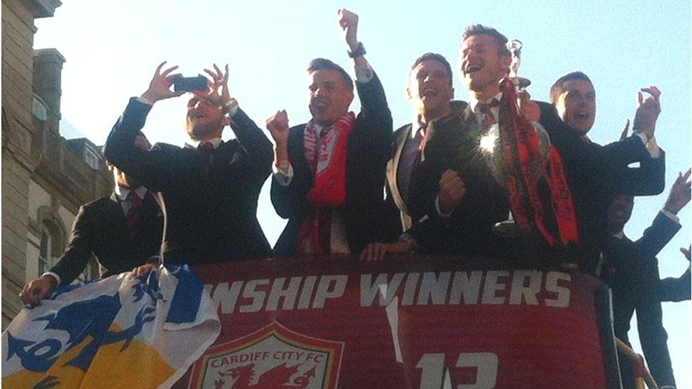 Cardiff players celebrate and one finds the time to take photos as they begin their bus parade to Cardiff Bay.