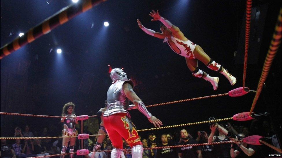 A lucha libre wrestler leaps through the air at the Mayan Theatre in Los Angeles