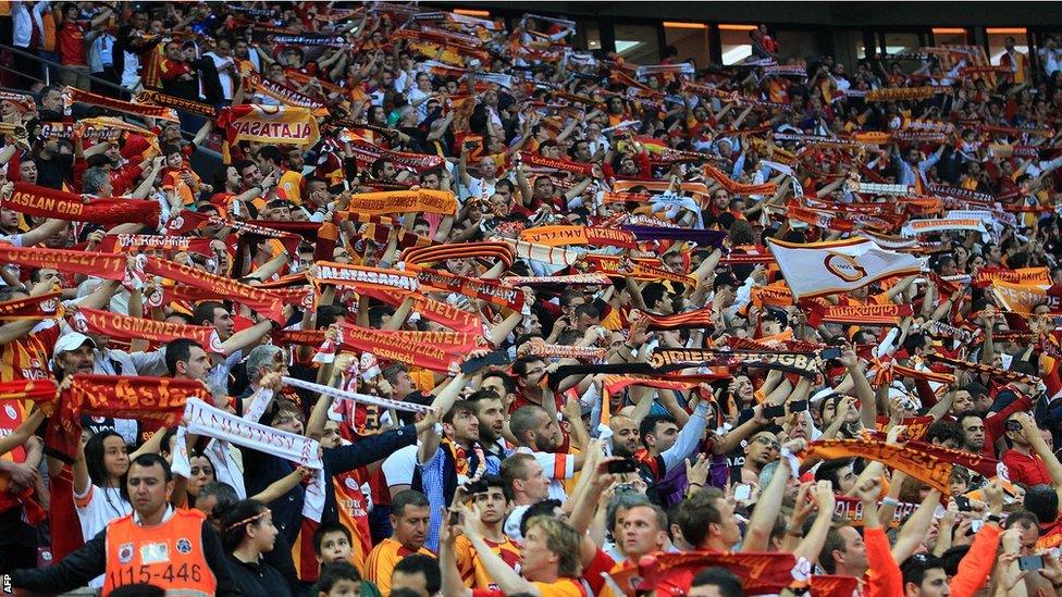 Galatasaray fans hold scarves as they support their team during the title winning match at the 52,652 capacity Turk Telekom Arena