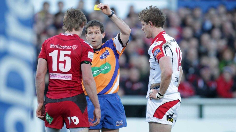 Referee Alain Rolland shows yellow cards to Liam Williams and Andrew Trimble after a first half brawl