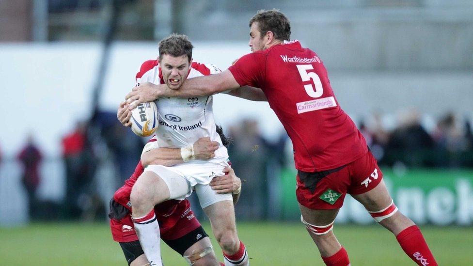 Ulster centre Darren Cave shrugs off the challenge of Scarlets lock Johan Snyman