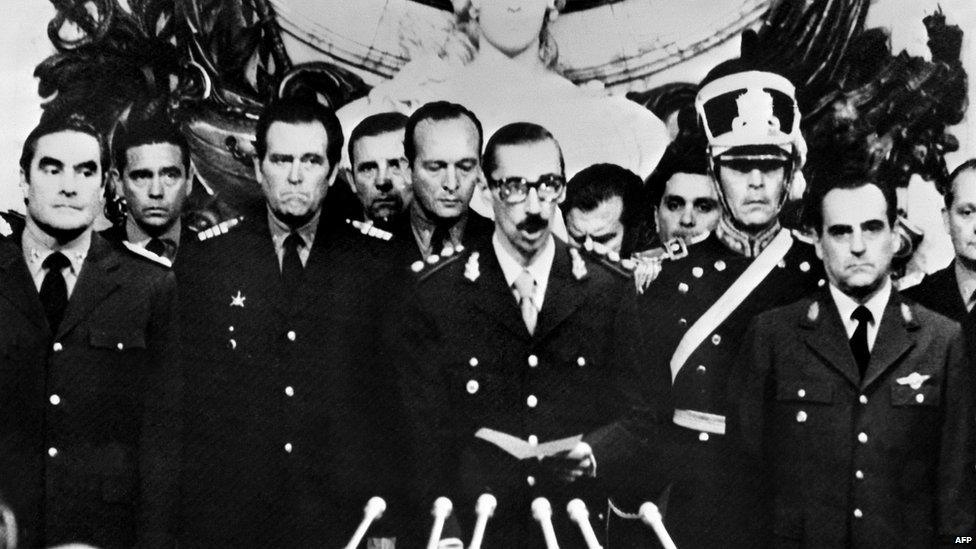 General Orlando Ramon Agosti (R) and Admiral Emilio Massera (L) stand as Lieutenant General Jorge Rafael Videla (C), President of Argentina, takes an oath as 38th president of the Argentine Republic, 29 March 1976, in Buenos Aires.