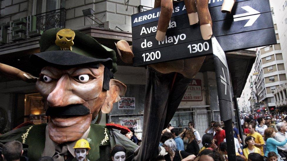 Demonstrators hold a figure representing Jorge Videla grabbing a street sign in Buenos Aires, 24 March 2006