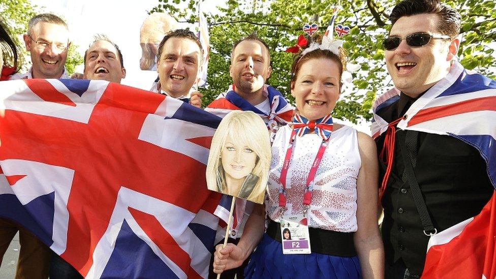 British fans hold national flags and a placard of Bonnie Tyler in Malmo, Sweden