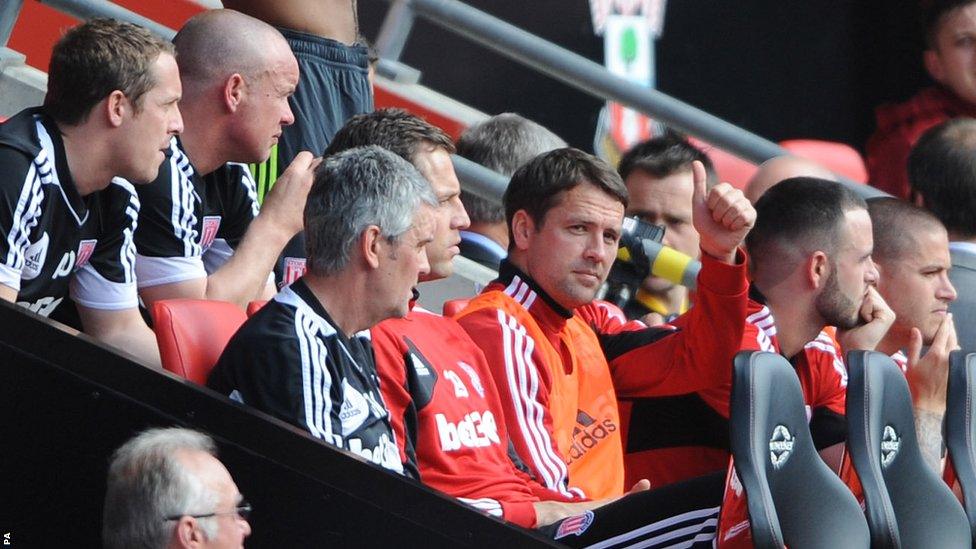 Michael Owen gives a thumbs-up signal from the Stoke bench