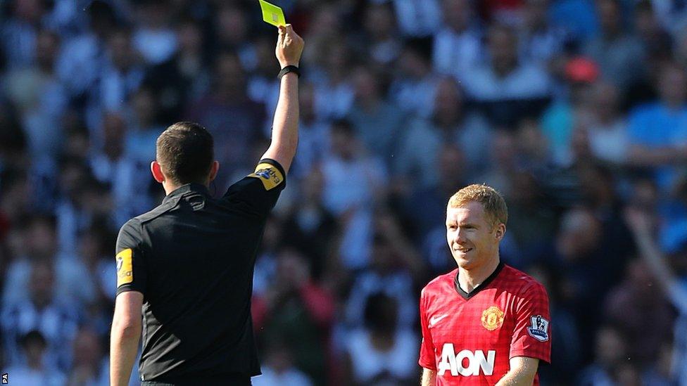 Paul Scholes is shown a yellow card by referee Michael Oliver