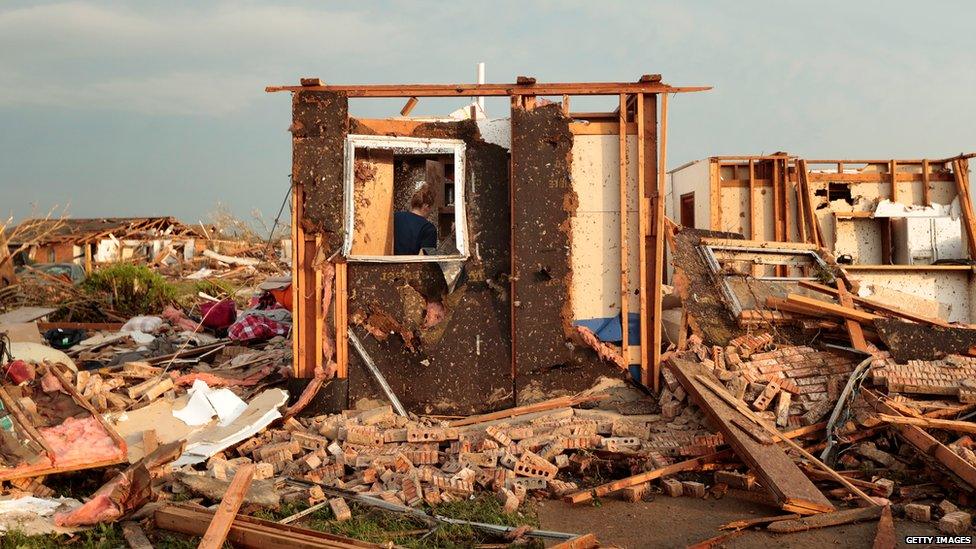 Dana Ulepich searches inside a room left standing at the back of her house