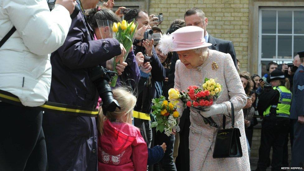 The Queen accepts flowers from children outside Cambridge railway station