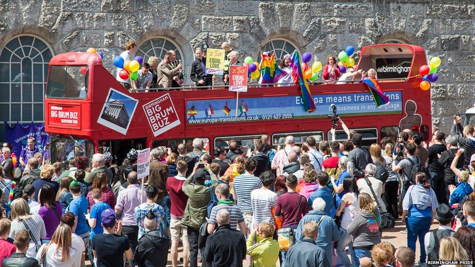 People on an open-top bus taking part in the parade