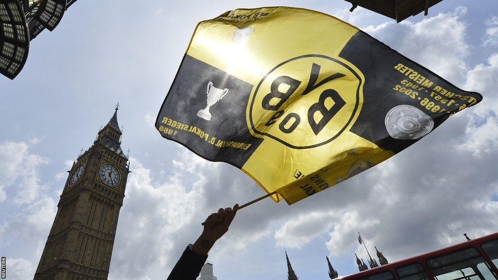 A Borussia Dortmund flag is waved in front of Big Ben