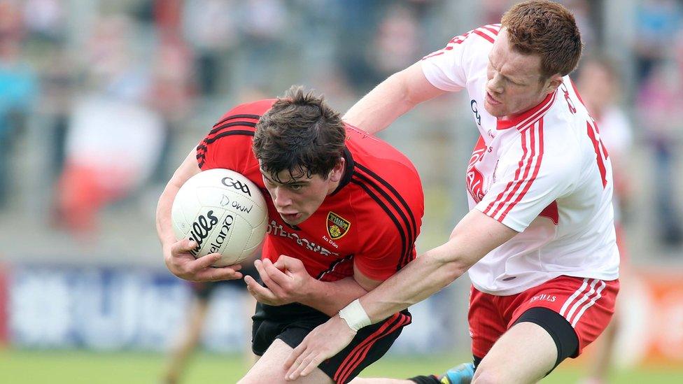 Niall Madine, who was making his championship debut for Down, is tackled by Aidan McAlynn