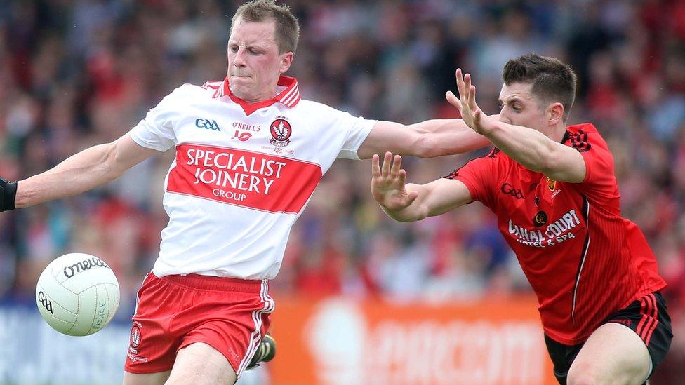 Derry's Brian McCallion attempts to get his kick away before Ryan Boyle comes in with a block