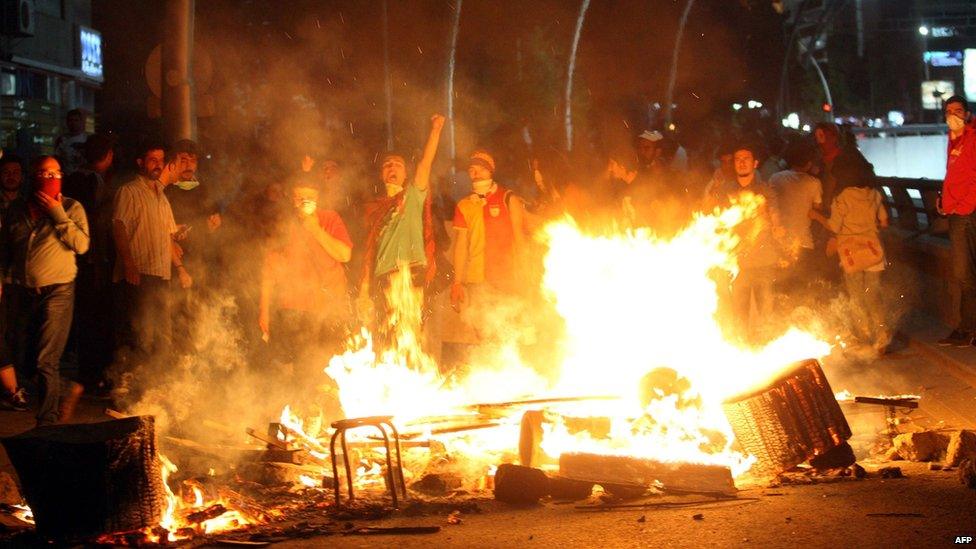 Protesters stand in front of makeshift fires in Ankara early on 3 June 2013.