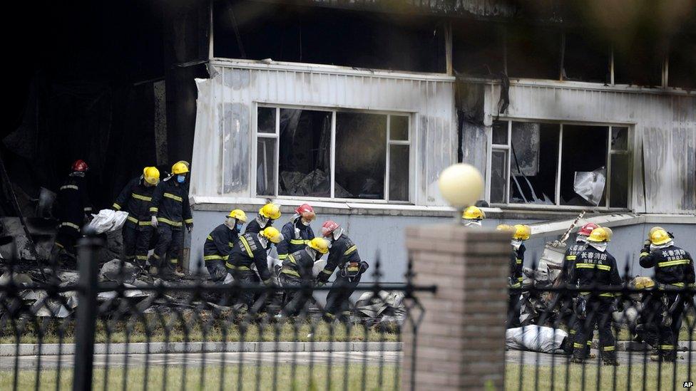 Firemen carry out body bags at a poultry processing plant that was engulfed by a fire in north-east China's Jilin province, 3 June 2013