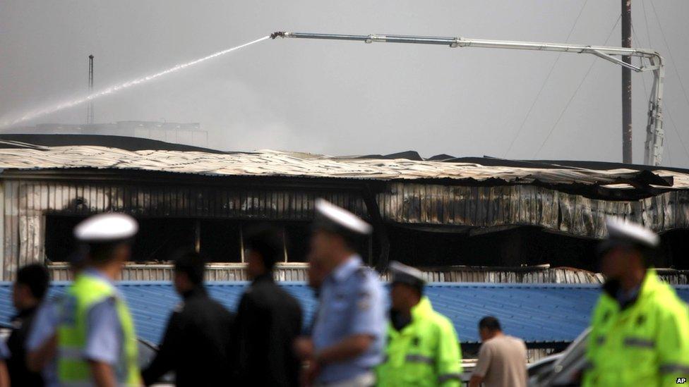 A water cannon douses down the roof of a poultry processing plant after a major fire in Dehui, north-east China's Jilin province, 3 June 2013