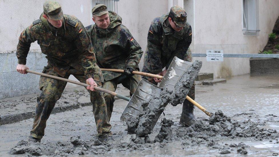 Soldiers shovel mud from the streets of Passau, Germany, on 4 June 2013