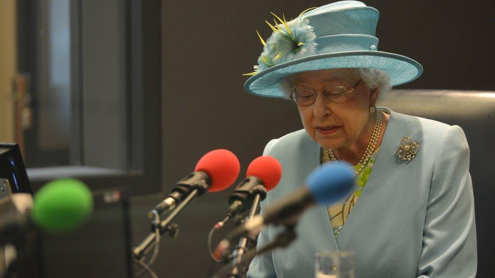 The Queen speaking into a microphone